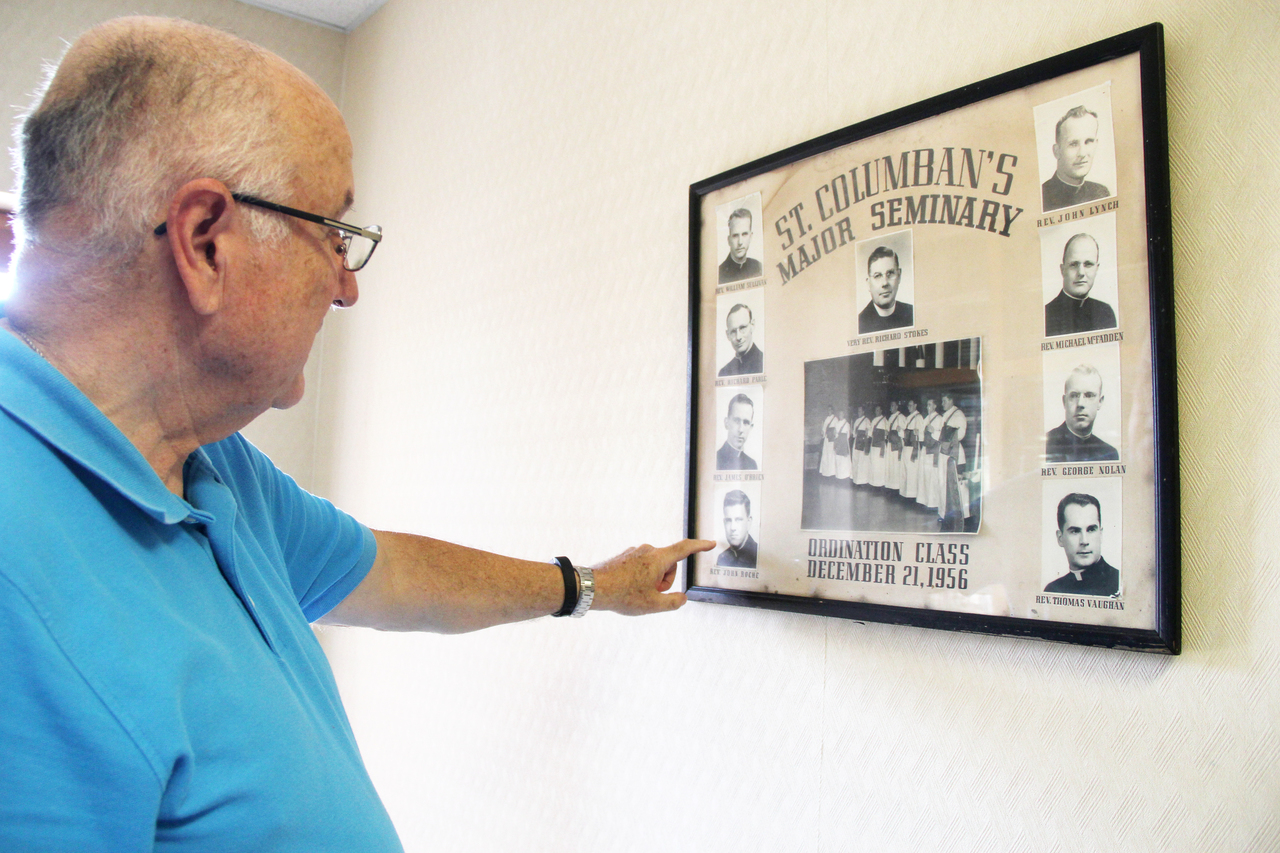 HOUSE OF PRAYER: At St. Columban's Retirement House in Bristol, Father John Burger, SSC, vice-director, showcases a framed photo of the 1956 ordination class of St. Columban's Major Seminary which includes Father John Roche who is in residence at the house.