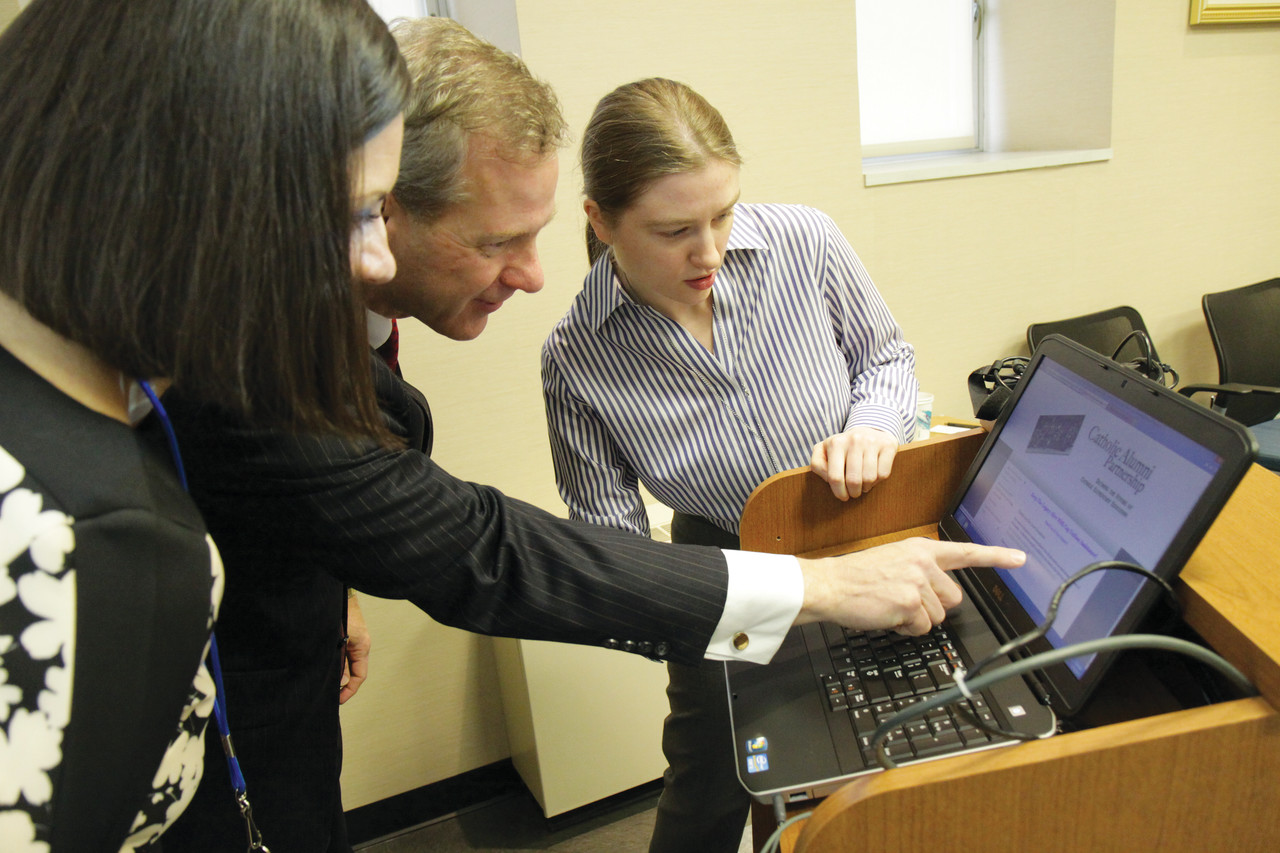GIVING BACK: Rebecca Page Perez, project manager, Daniel Ferris, superintendent of Catholic schools, and Victoria Chapman, development assistant in the Office of Stewardship and Development, examine the Catholic Alumni Partnership’s new online giving portal during a launch ceremony last Thursday.