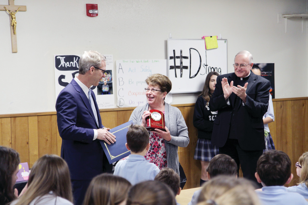 Daniel Ferris, superintendent of schools for the Diocese of Providence, presented Principal Joan Sickinger of St. Peter Tri-Parish School, Warwick, with the Distinguished Principal Award last Wednesday during a surprise morning assembly that also marked the celebration of her birthday.