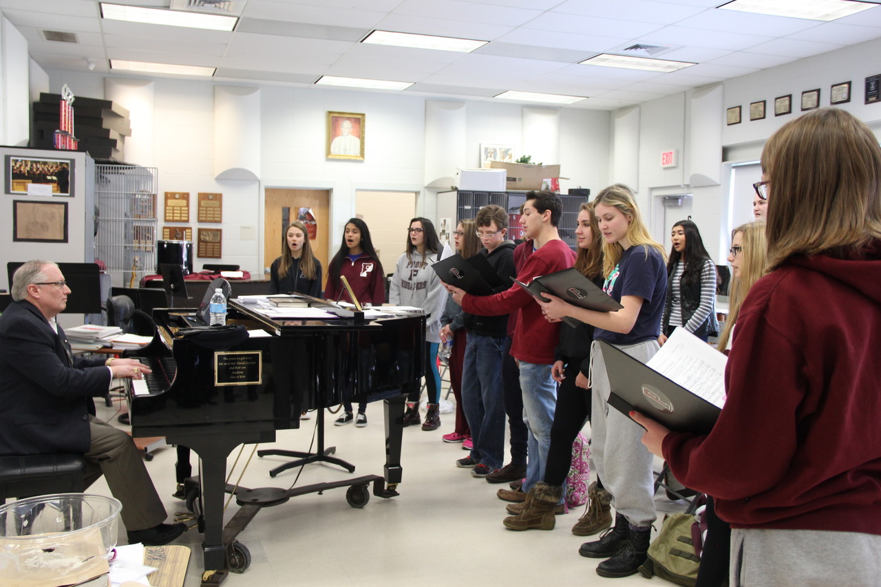 Hours before boarding the bus to Boston’s Logan International Airport, Phil Faraone, Prout’s Music Director, practice the sacred music repertoire with the choir.