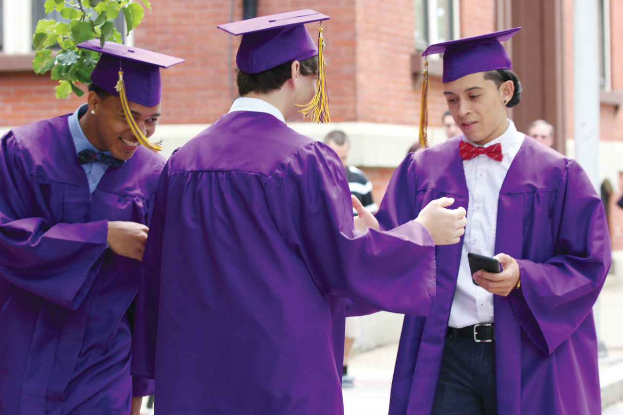 Graduates Kevin Gonzalez, left, who will attend the University of Massachusetts at Dartmouth on a football scholarship; Nick Berry, who will attend URI; and Pablo Estrada Jr., who will attend Newbury College, greet each other outside the cathedral before the ceremony.