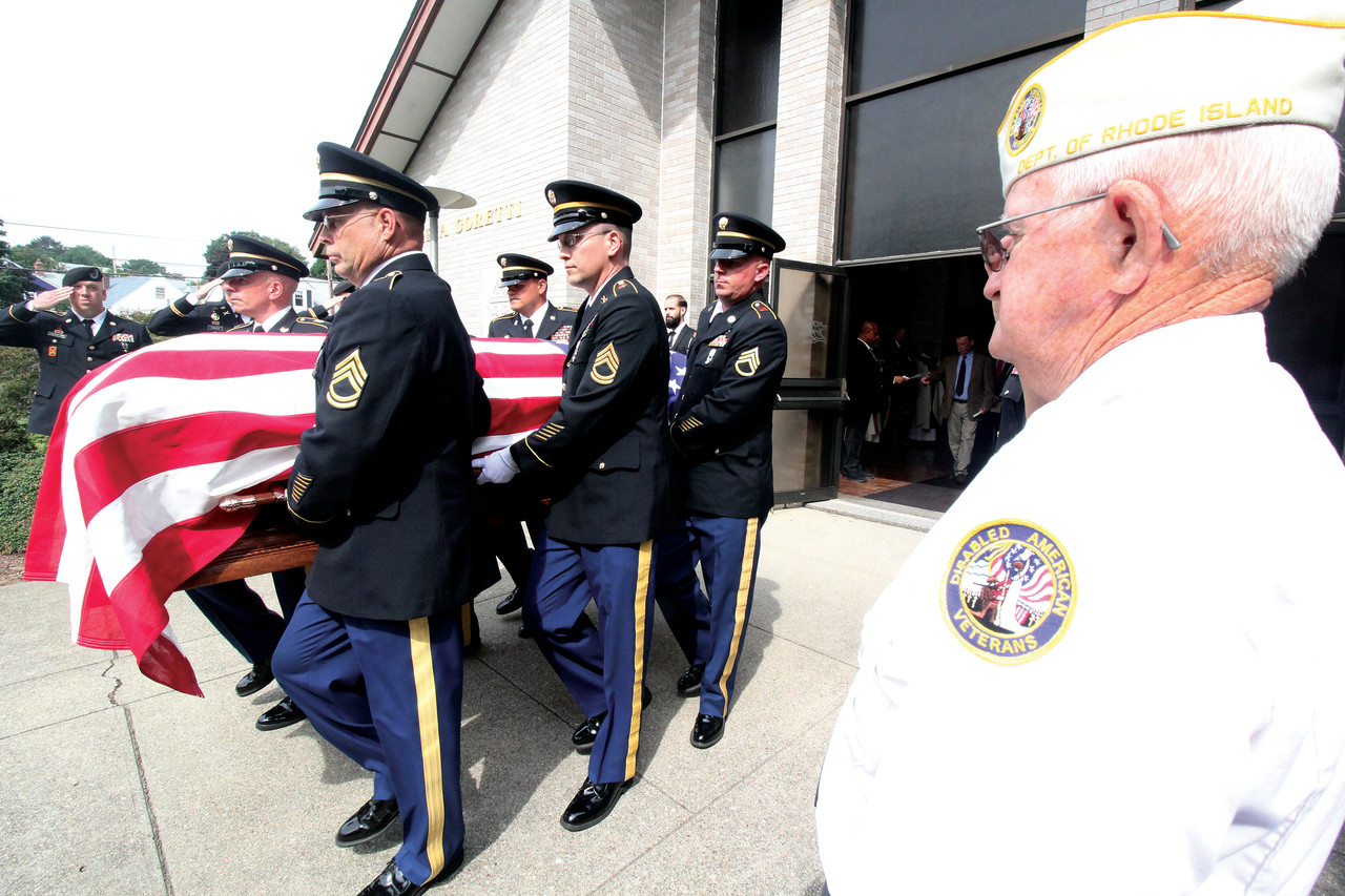 A military honor guard carries the casket bearing the remains of Capt. Elwood Joseph Euart from St. Maria Goretti Church following a Mass of Christian Burial and prepare to bring the once lost at sea World War II soldier to his final resting place at nearby St. Francis Cemetery.