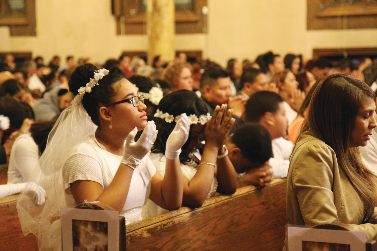 bienvenidos a la iglesia: El Padre Jaime Garcia ofrece la Comunión, 41 candidatos recibieron los sacramentos durante la Vigilia de Pascua.
