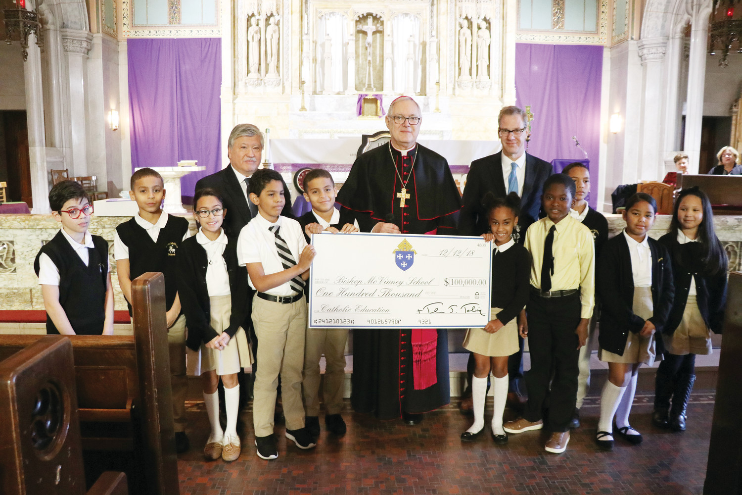 Bishop Thomas J. Tobin presents Bishop McVinney School in Providence with a $100,000 donation from the Diocese of Providence to help pay for improvements at the inner-city school.