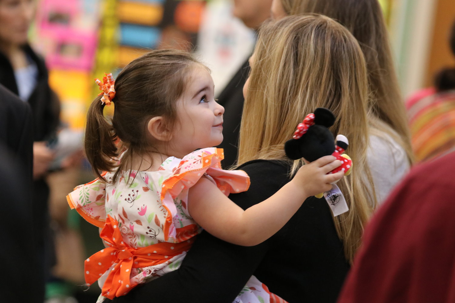 A mom and daughter wait for the ceremony to begin in the school gym.