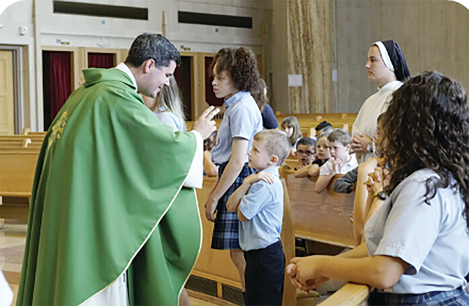 A St. Pius V student receives a blessing from Father Patrick Mary Briscoe, O.P., during a school Mass. The mission and foundation of Catholic education are directly related to evangelization, said Thomas Burnford, head of the National Catholic Educational Association.