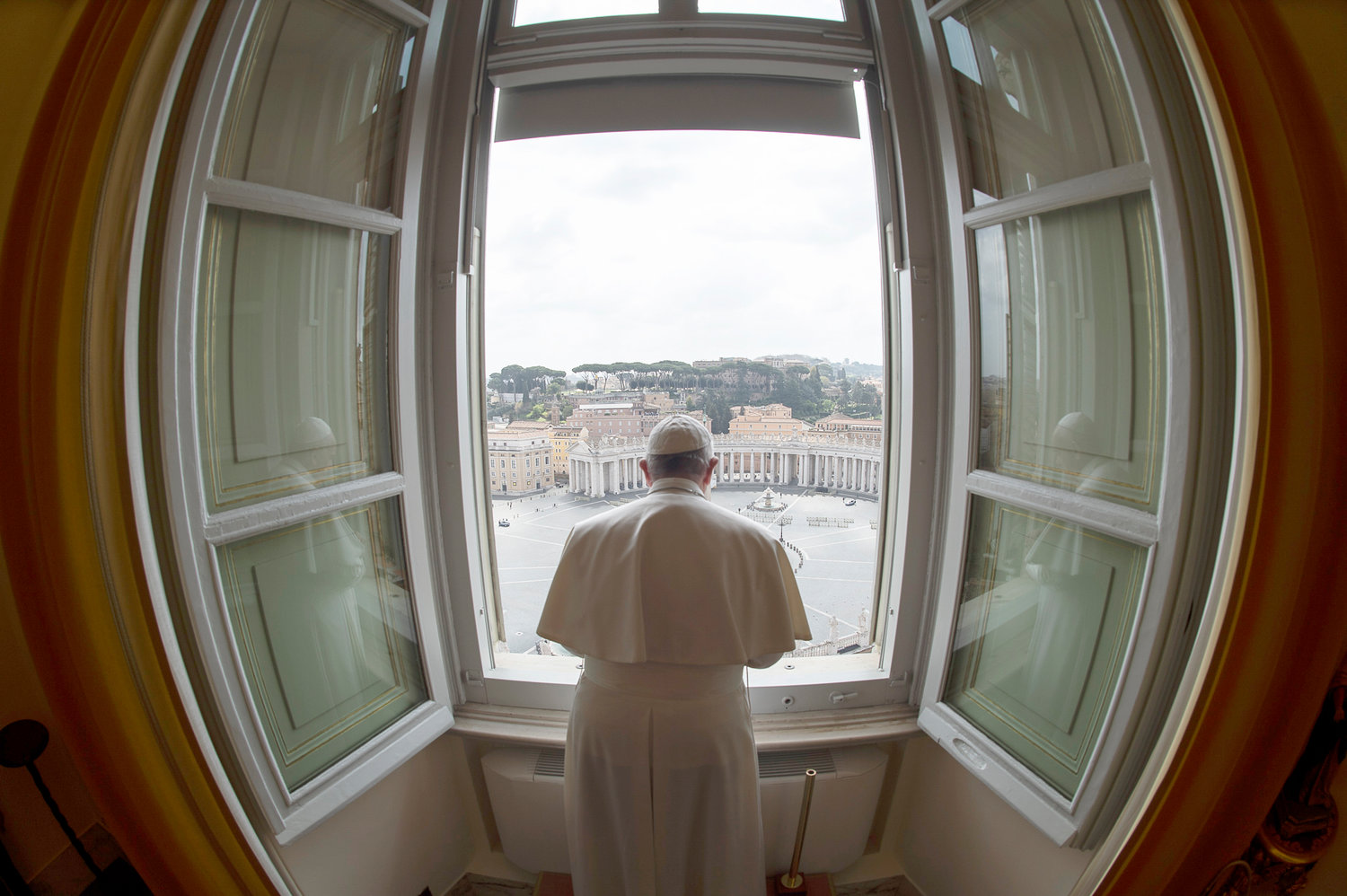 Standing in the window of the library of the Apostolic Palace overlooking an empty St. Peter's Square, March 29, 2020, Pope Francis blesses the city of Rome, still under lockdown to prevent the spread of the coronavirus.