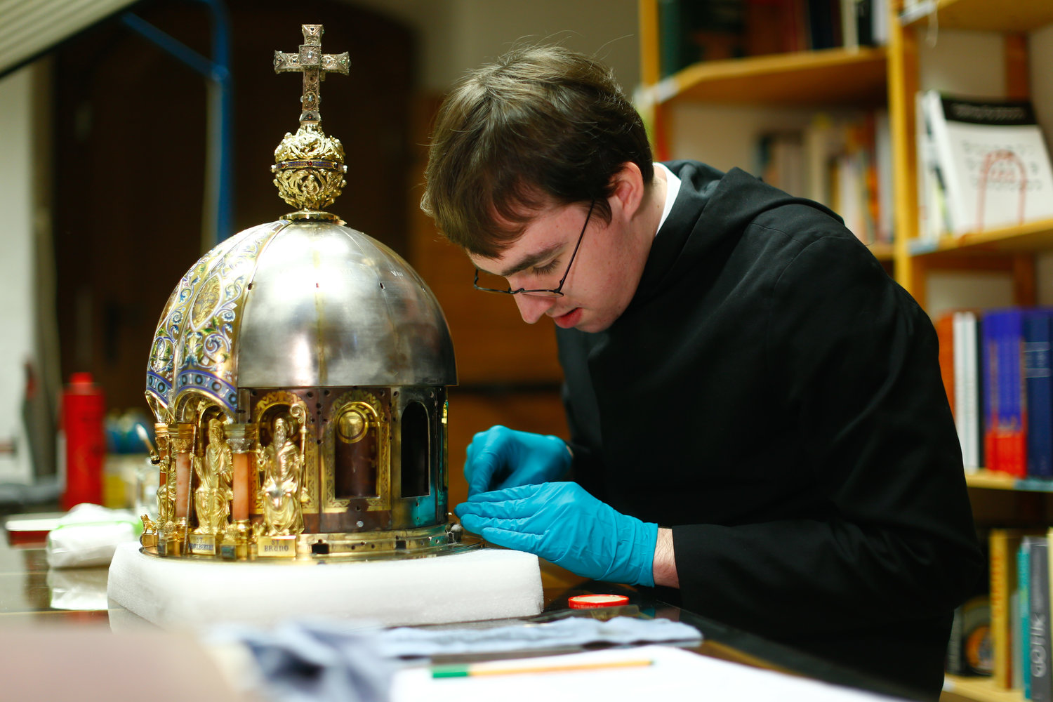 Restorer Luke Jonathan Koeppe cleans part of the shrine with the relics of St. Corona at the cathedral in Aachen, Germany, March 25, 2020, amid the coronavirus pandemic.