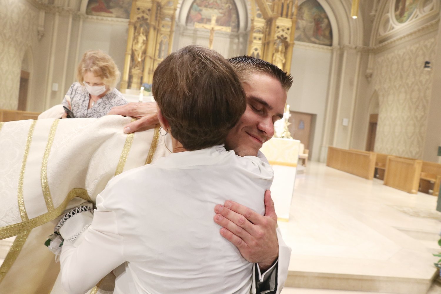 Deacon Gadoury shares a loving moment with his mother, Cheryll Gadoury, following his ordination.