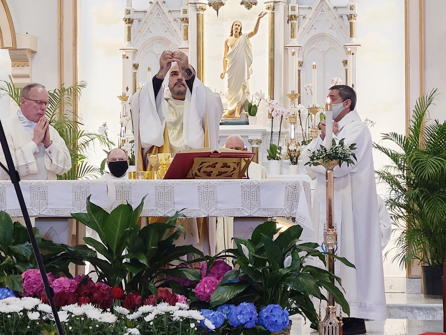 Father Ezio Antunes, CSP, consecrates the Eucharist during the Memorial Mass in honor of St. Elizabeth Church’s late pastor Father Marinaldo Batista, who died from COVID-19 complications in his native Brazil on April 1, Holy Thursday.