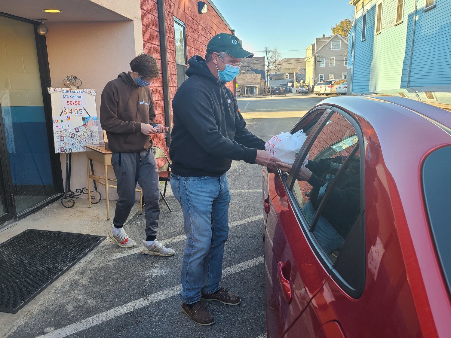 A volunteer brings out a customer’s food order on March 12 during Our Lady of Mount Carmel Church’s drive-through parish fish fry in Bristol.