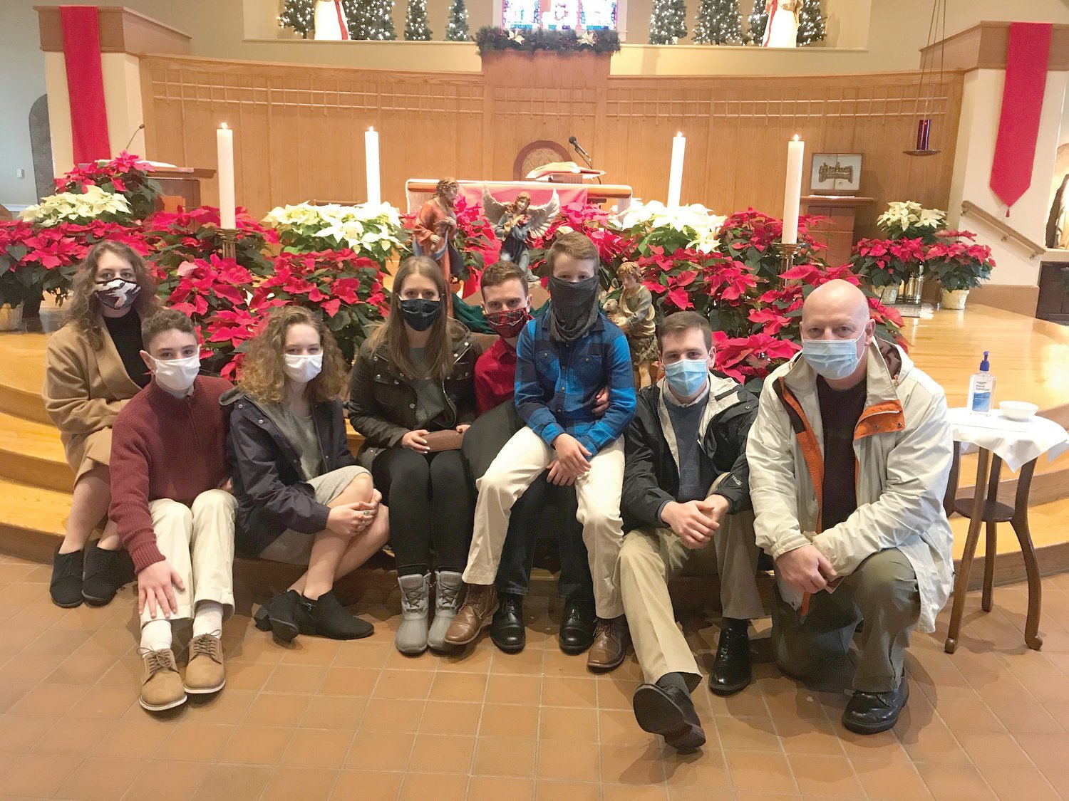 Members of the McInnis family pause to take a family photo after the Christmas Vigil at Holy Apostles Church, Cranston, to remember that there’s no place they would rather be to celebrate the birth of Jesus. Several churches across the diocese reported they were at capacity for Masses as they adhered to the state’s COVID-19 pandemic restrictions on large gatherings.