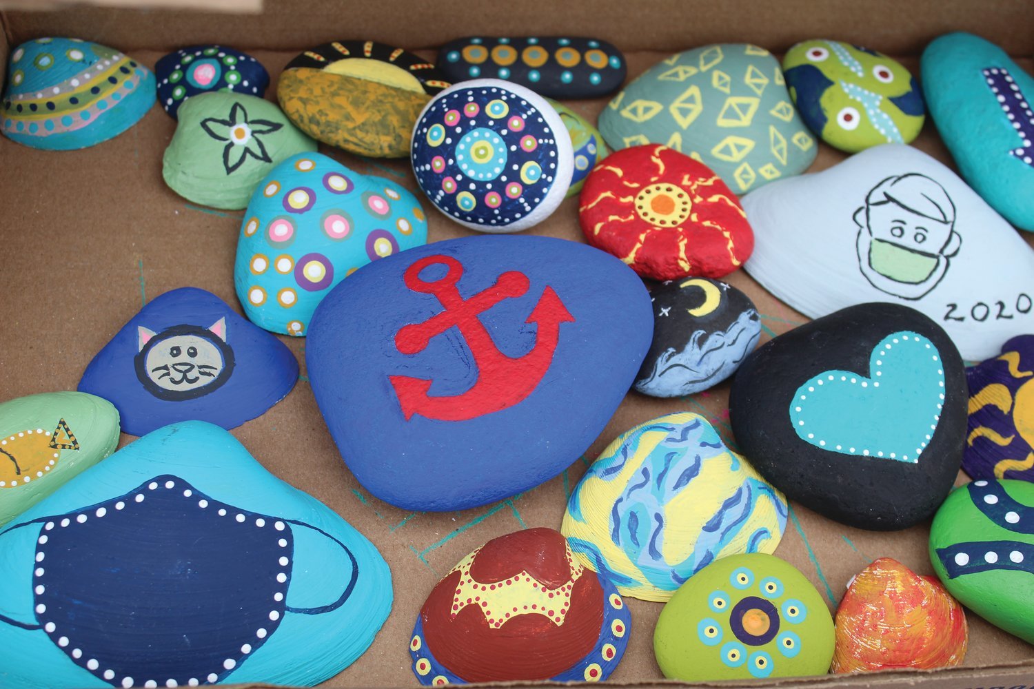 Alongside traditional Rhode Island motifs like anchors, waves and sea life, the shells painted by the Raucci family also feature a few distinctly 2020 references — namely the familiar face masks that have become commonplace in the wake of the pandemic. Scarlett sold these (and many other designs) at the socially distanced shell-stand which she set up earlier this year at Jerry Brown Farm.