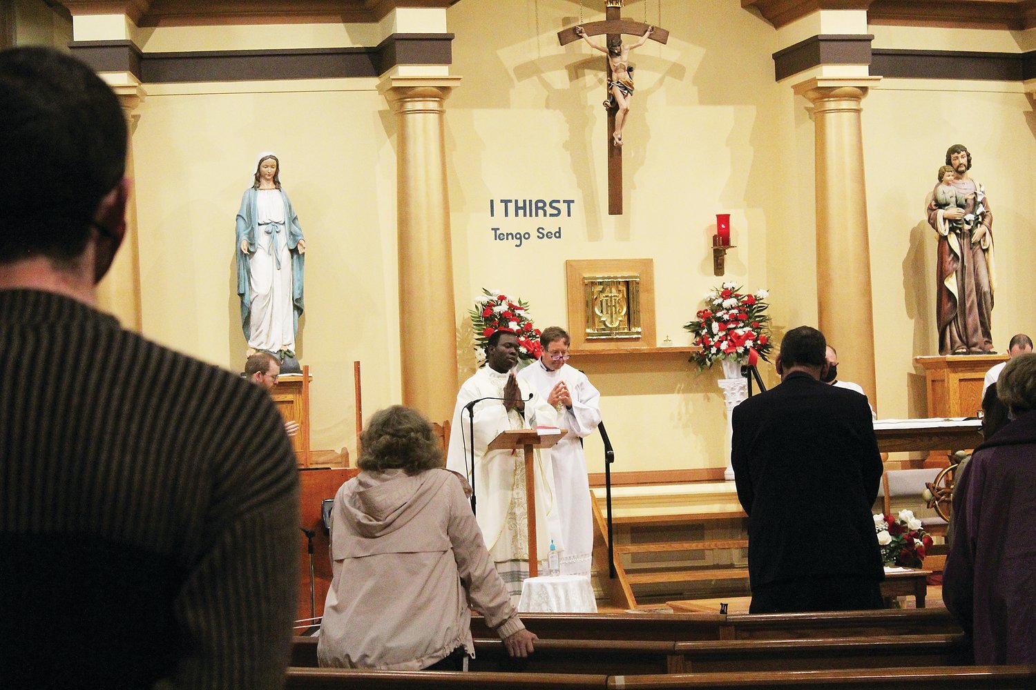 Father Joseph Brice celebrates the Mass at St. Patrick Church, Providence, assisted by Deacon Dr. Timothy Flanigan, an infectious disease specialist.