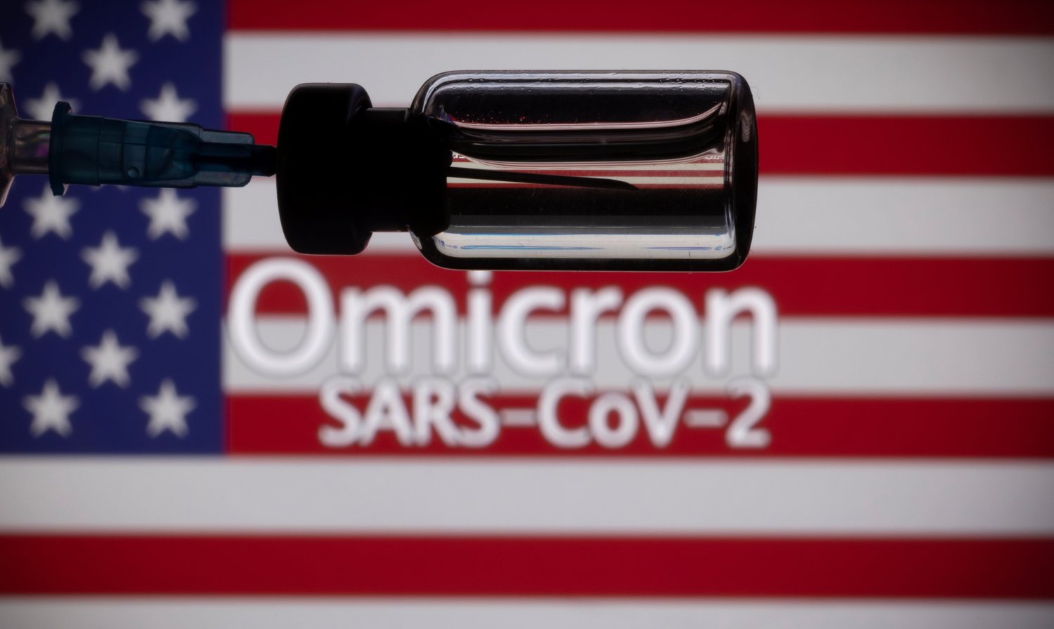 A vial, syringe and U.S. flag are seen in this Omnicron coronavirus illustration photo.