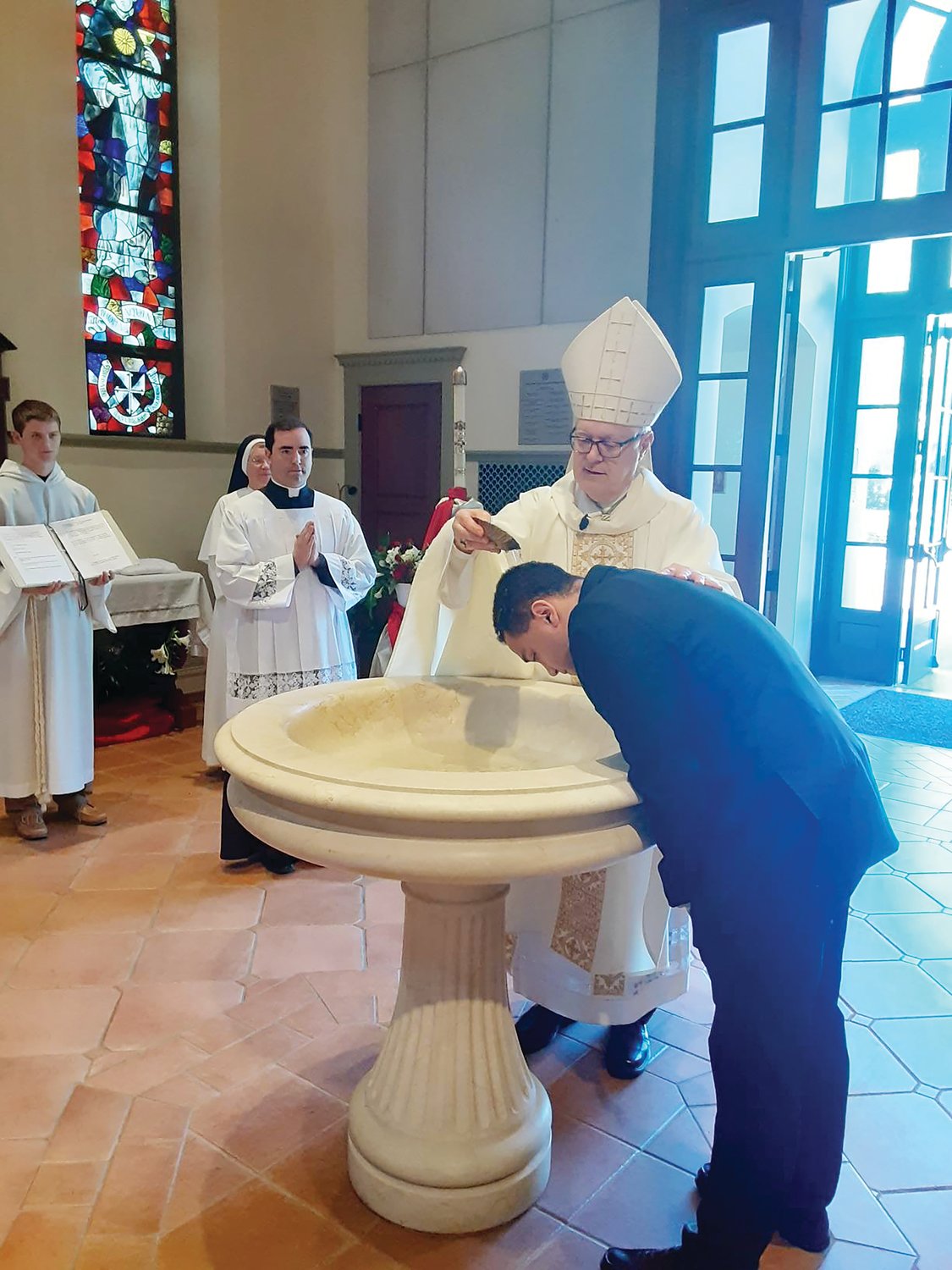 Providence College students were baptized and received into the Church on Sunday, May 1. Above, Bishop Thomas J. Tobin baptizes Siavash Mirazedeh at St. Dominic Chapel.