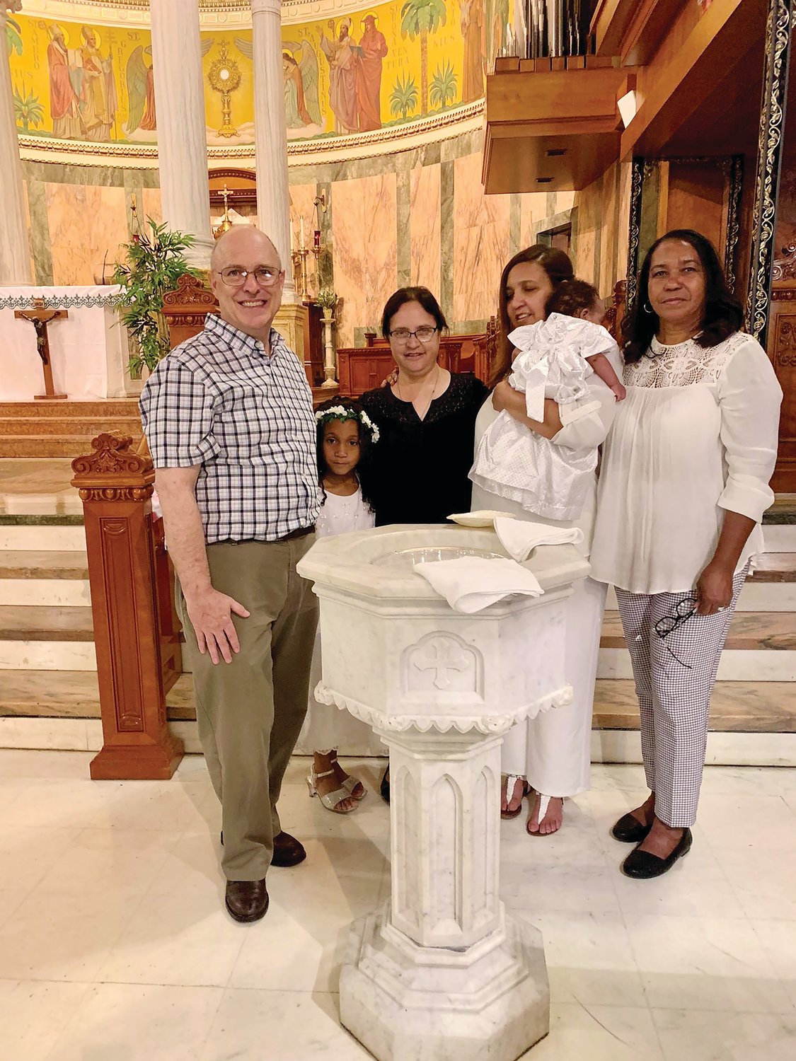 Marissa y su esposo Thomas junto con Vilma y su bebé en Blessed Sacrament. Marissa Kelly sirve en el proyecto Gabriel, un ministerio diocesano de los servicios sociales católicos de Rhode Island Island