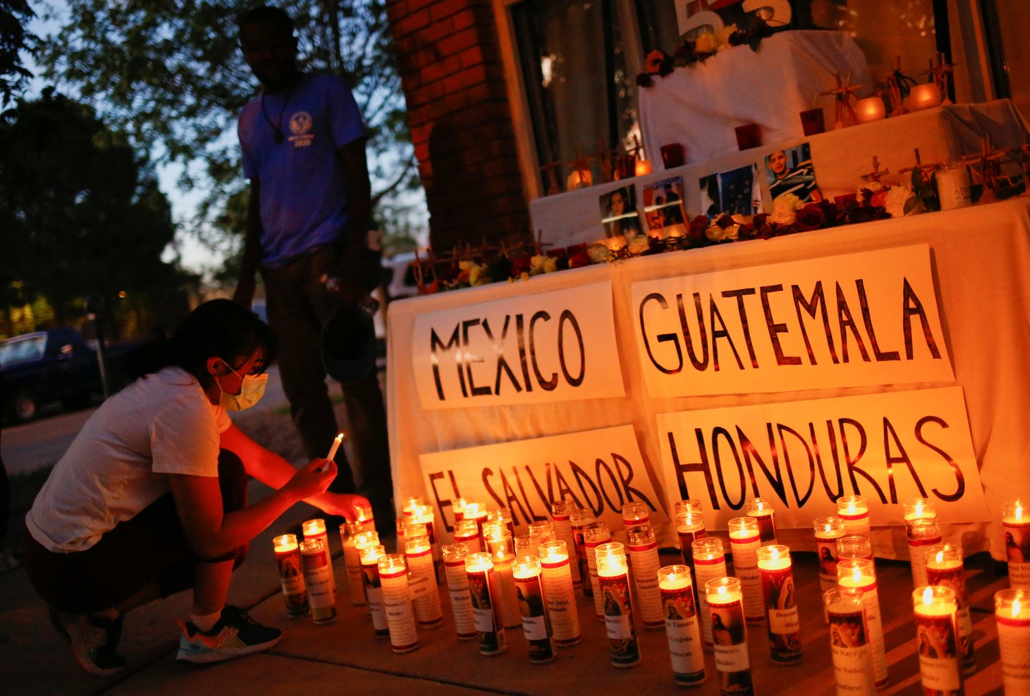 A woman in El Paso, Texas, lights candles during a vigil July 5, 2022, to honor the 53 migrants who died in a cargo truck in San Antonio June 27. (CNS photo/Jose Luis Gonzalez, Reuters)