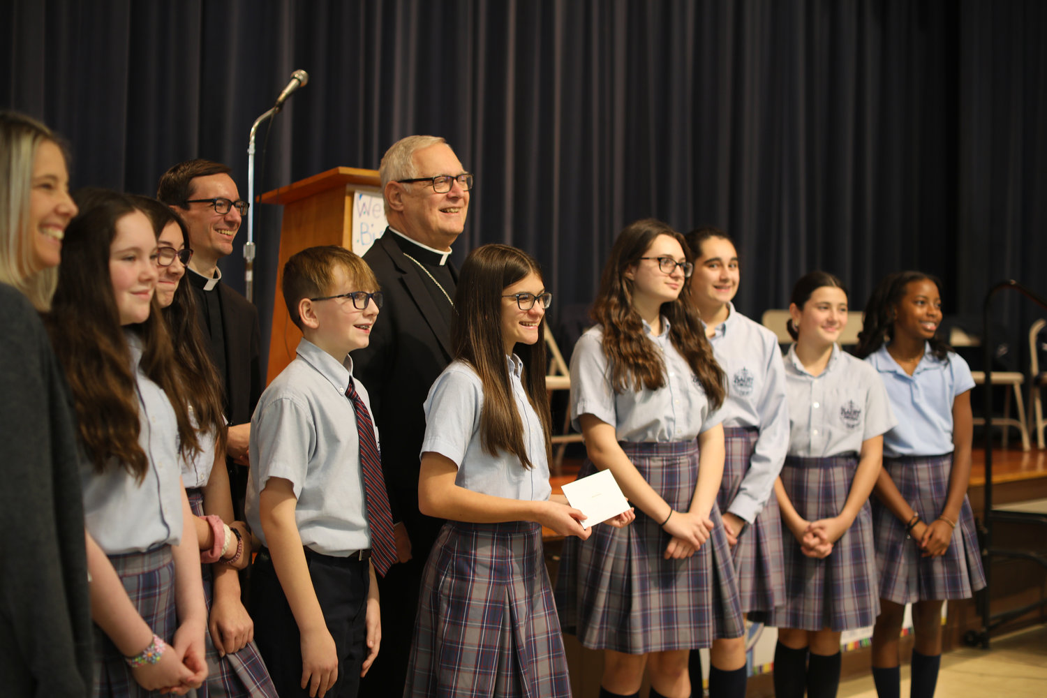 Bishop Thomas J. Tobin smiles with the Saint Cecilia Middle School Student Council, Father Stephen Battey, pastor of Saint John Paul II Parish, and principal Kelly Caton during the kickoff of the 2022 ‘Keep the Heat On’ program.