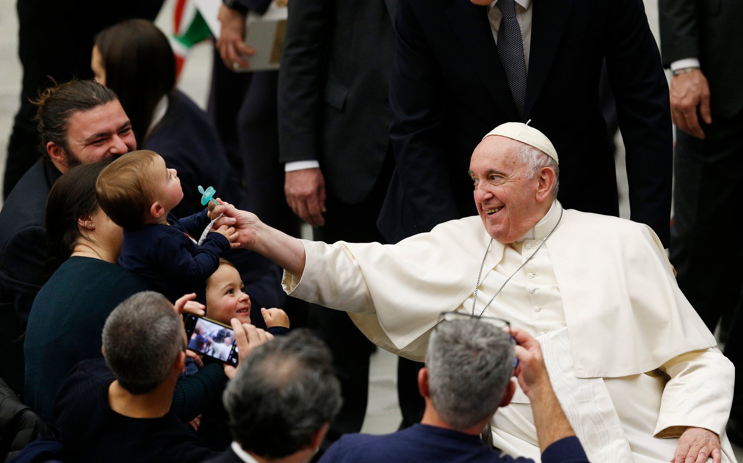 Pope Francis touches the pacifier of a child during his general audience in the Paul VI hall at the Vatican Dec. 14, 2022. (CNS photo/Paul Haring)