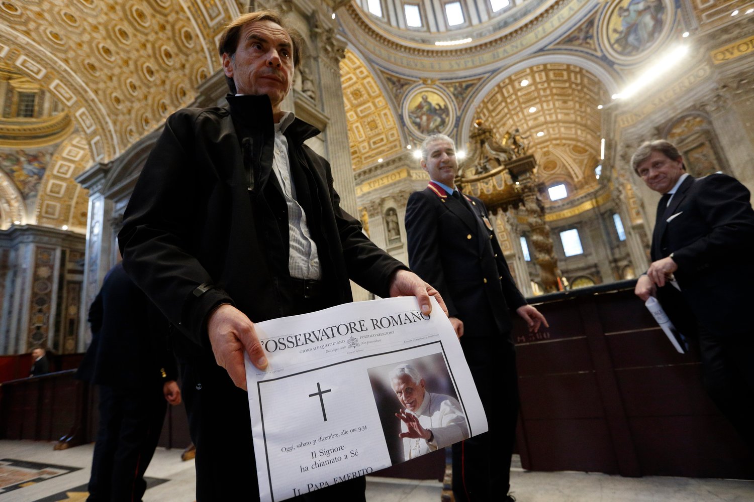 A man holds a copy of the Vatican's L'Osservatore Romano newspaper announcing the death of Pope Benedict XVI, in St. Peter's Basilica at the Vatican Dec. 31, 2022. Pope Benedict died at the age of 95 in his residence at the Vatican. (CNS photo/Paul Haring)