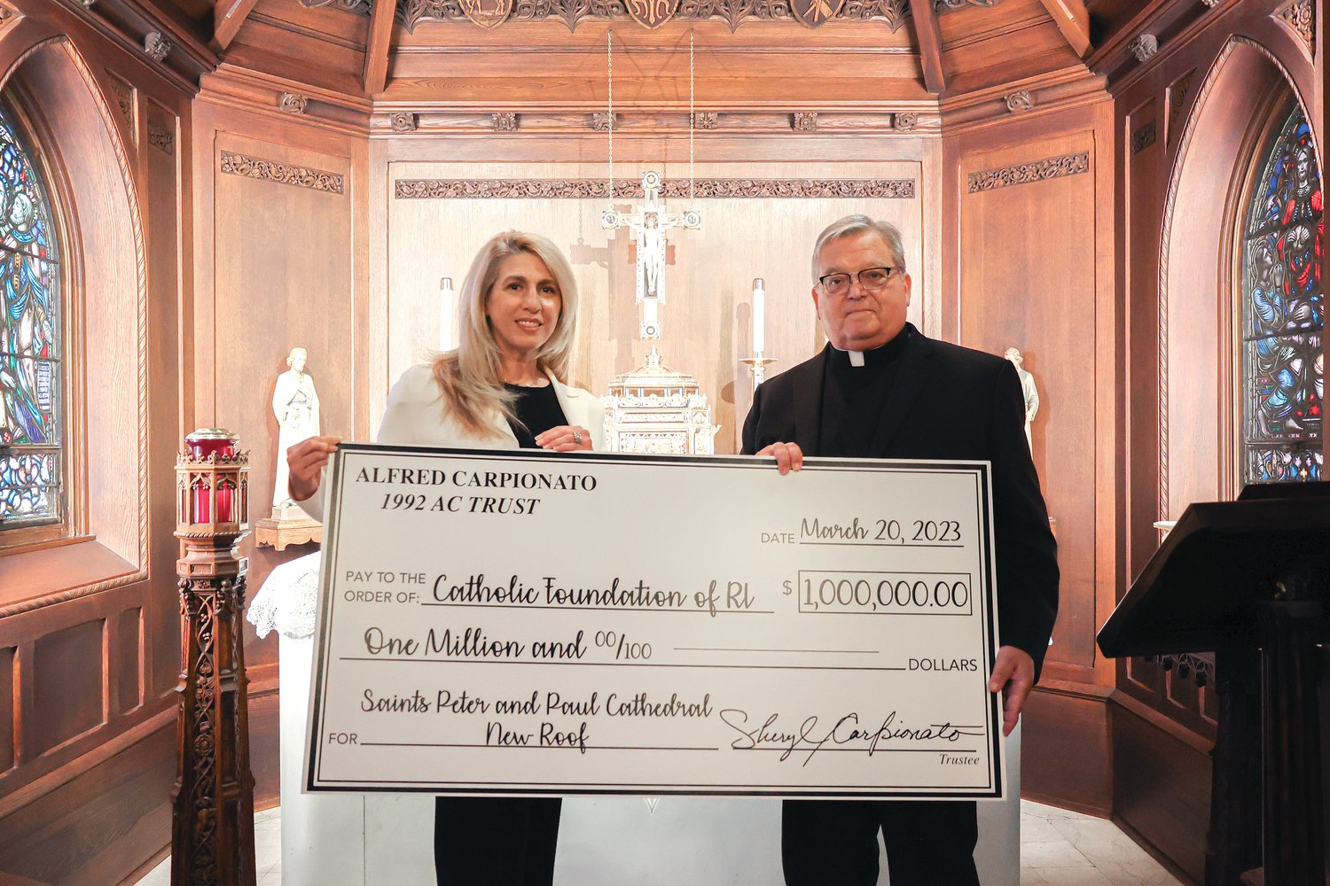 Sheryl Carpionato presents Cathedral of SS. Peter and Paul Rector Msgr. Anthony Mancini with a check for $1 million on March 20, carrying out her late husband’s wishes to help restore the cathedral’s slate roof, which was replaced in 2020 for $4.5 million.