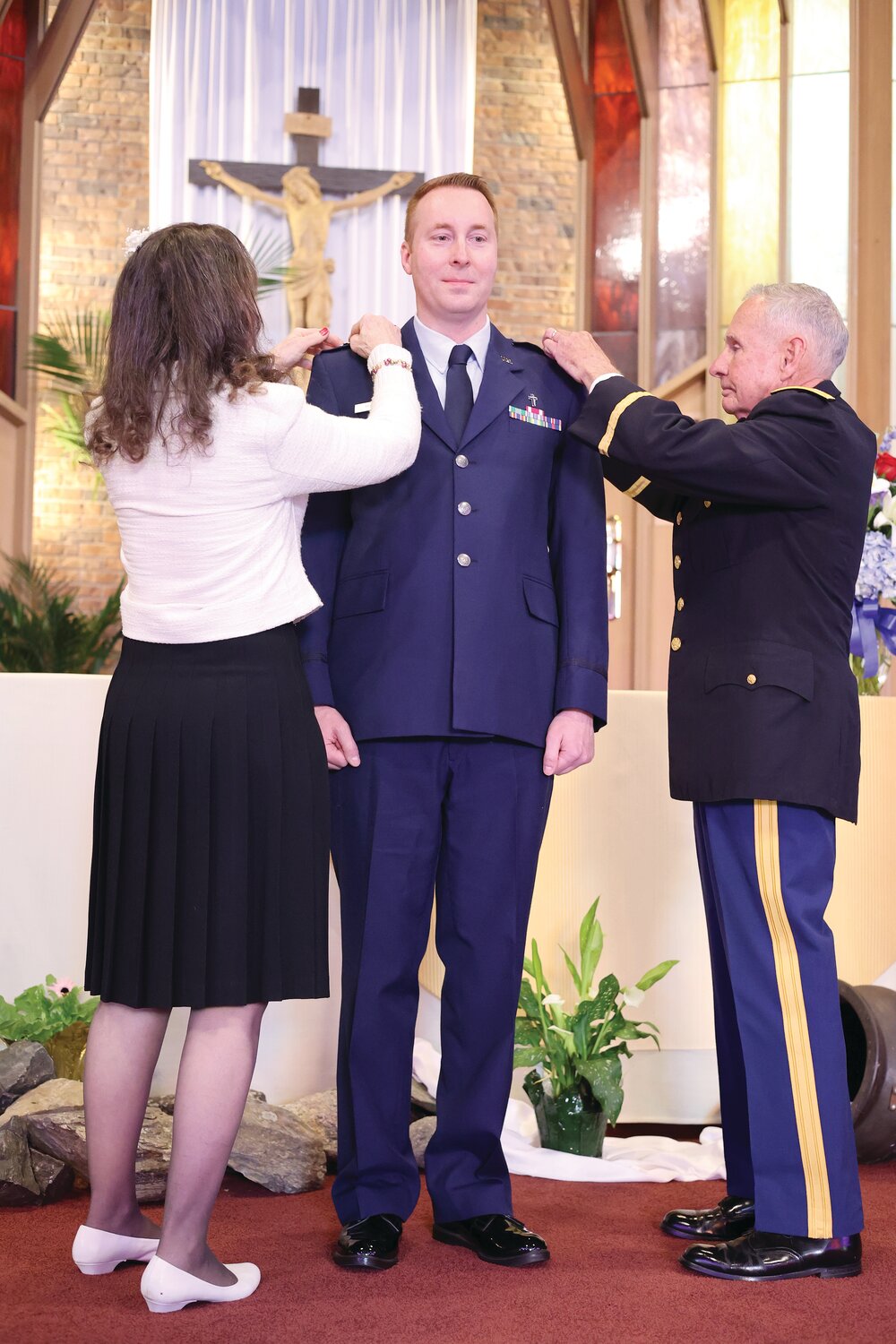 Lt. Col. Father David G. Thurber Jr. looks on as his mother, Suzanne Gregoire, and retired Col. Paul St. Laurent pin his new rank upon his shoulders during the promotion ceremony on April 24.