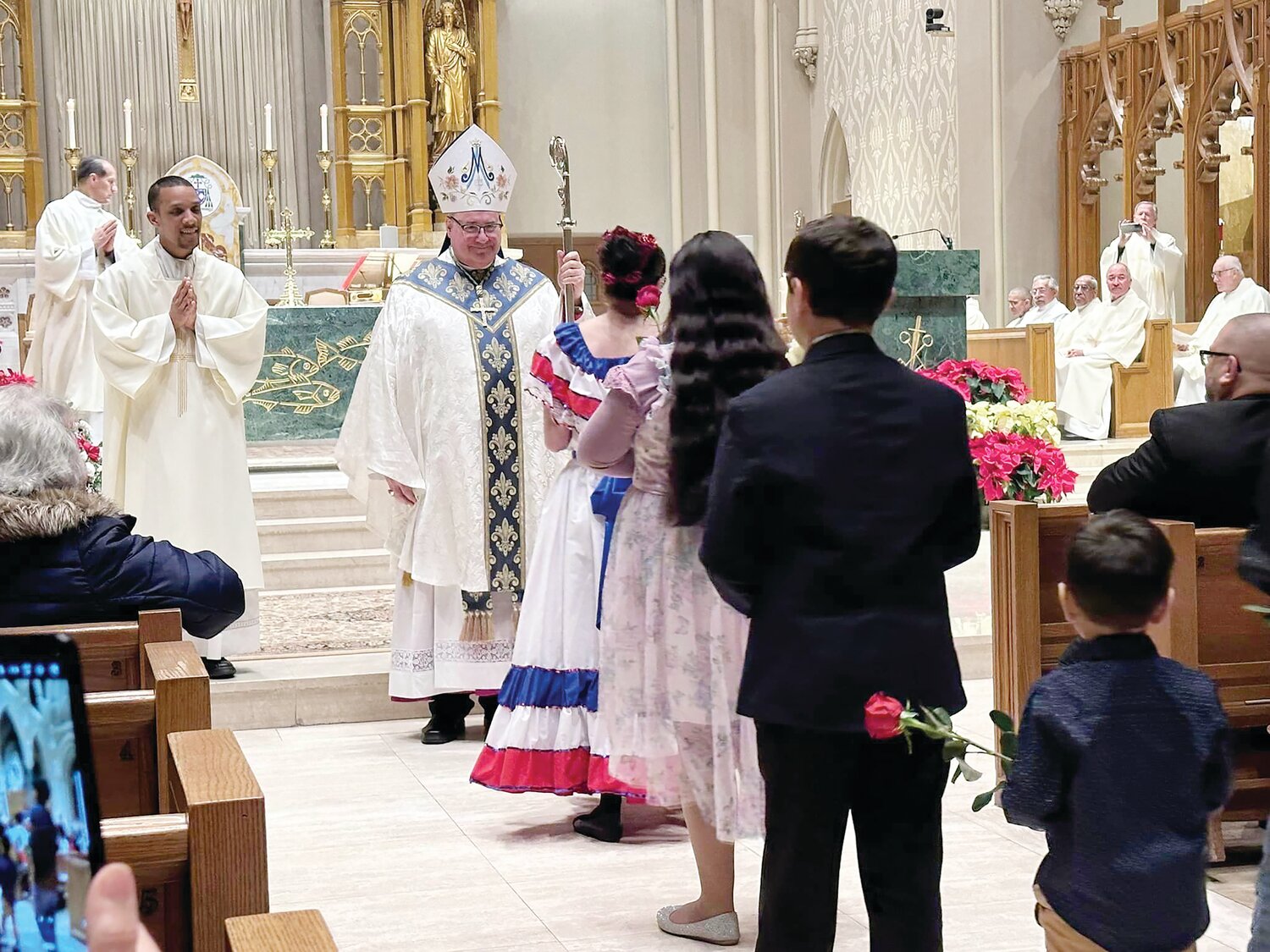 Misa a La Virgen de la ALtagracia: El Obispo Richard G. Henning recibe las ofrendas acompañado por el seminarista Jairon Olmos el pasado 19 de enero en la Catedral de San Pedro y San Pablo.