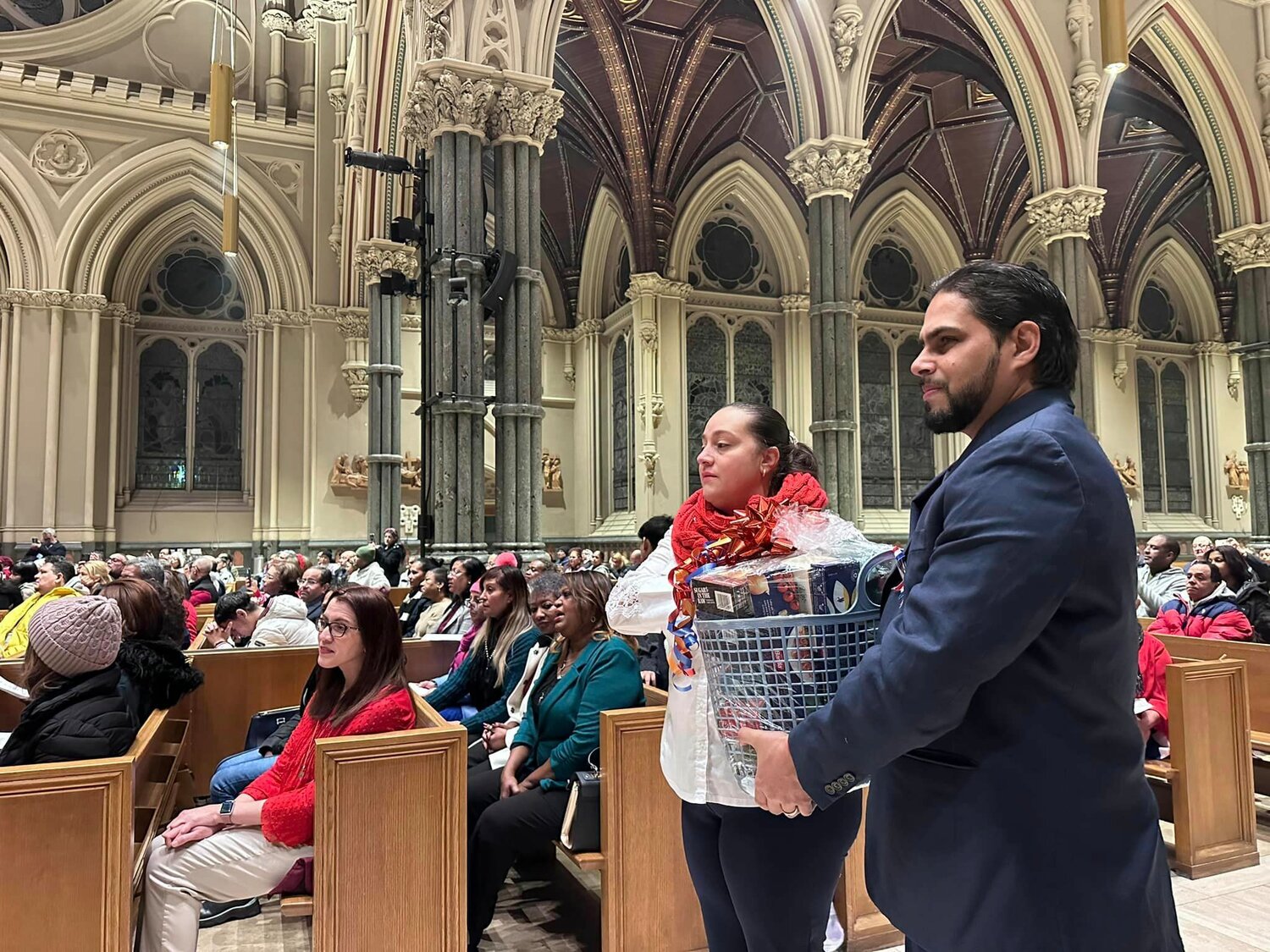 El candidato al Diaconado Jimmy Aibar y su esposa Wendolyn, llevan una canasta durante el ofertorio de la Misa diocesana a la Virgen de la Altagracia en la Catedral de San Pedro y San Pablo el pasado 19 de enero.